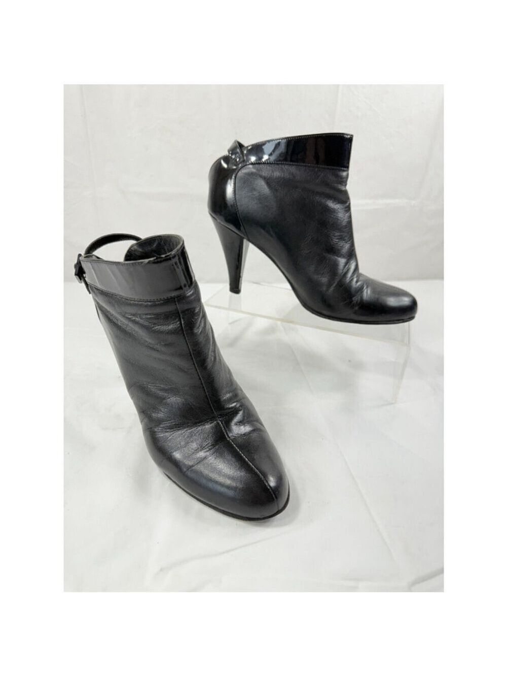 Chanel leather ankle boots featuring a distinct buckled Chanel logo strap detail